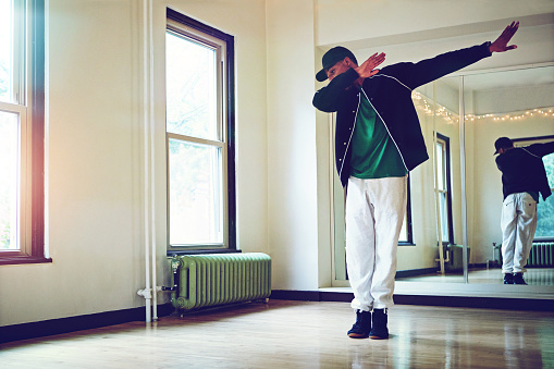 Shot of a young man dabbing during a dance routine in studio