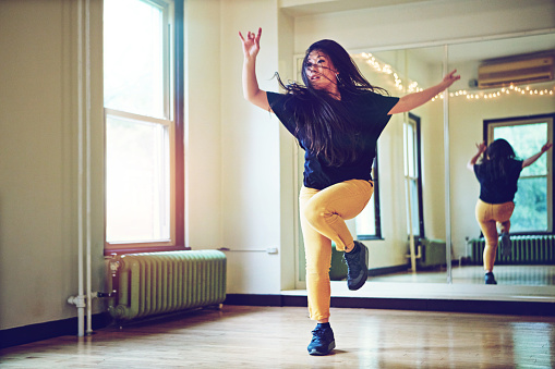 Shot of a young woman dancing in a studio