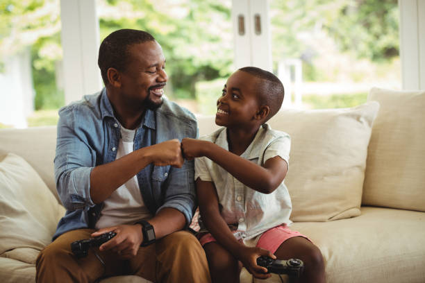 istock Father and son fist bumping while playing video game 646023506