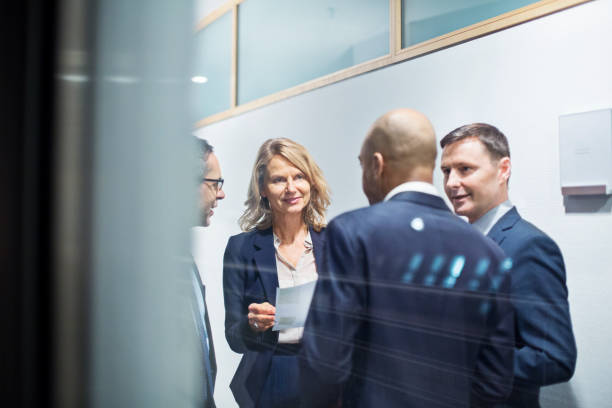 Business people having a standing meeting in office corridor
