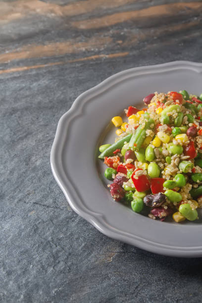 istock Fresh quinoa salad with peas, beans and peppers. Gray background 646029464