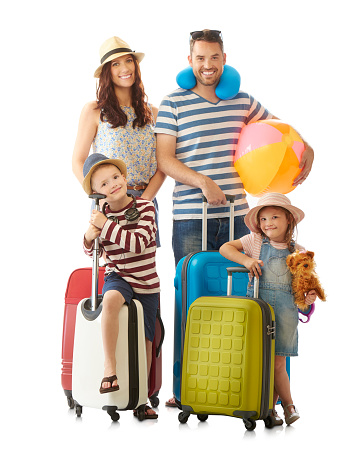 a young family pose with their luggage all set for a summer holiday