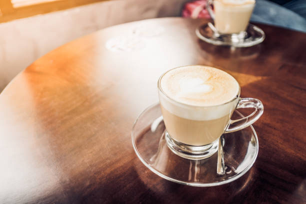 istock Latte coffee in cup on wood table top in cafe 646035990