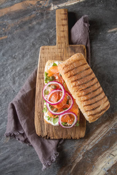 baguette casera con salmón ahumado, cebolla y rúcula. b oscura - 12018 fotografías e imágenes de stock
