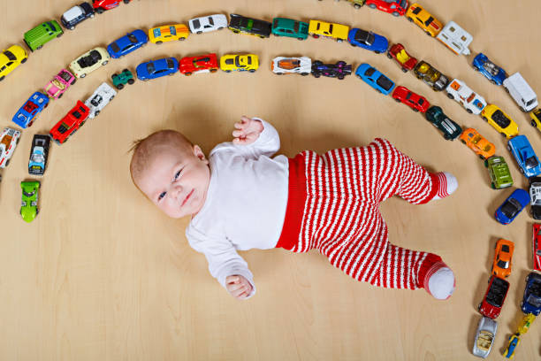 かわいい新生児赤ちゃんのおもちゃの車がたくさん遊んで - portrait germany party bed ストックフォトと画像