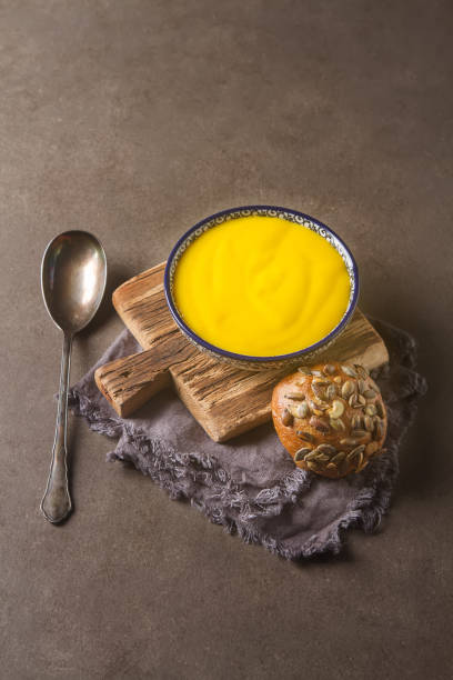istock Smoothies yellow. Bread soup spoon. Gray background. 646043612