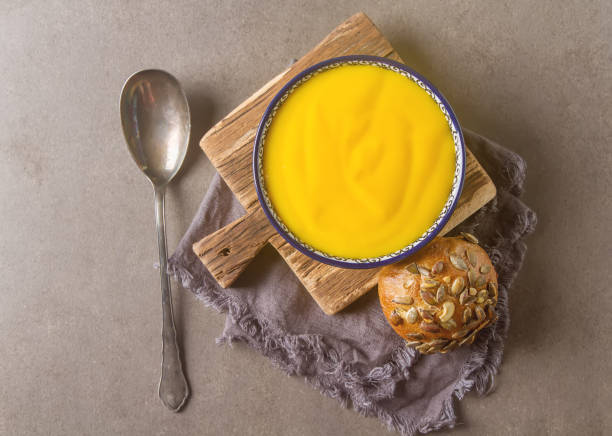 istock Smoothies yellow. Bread soup spoon. Gray background. 646043694