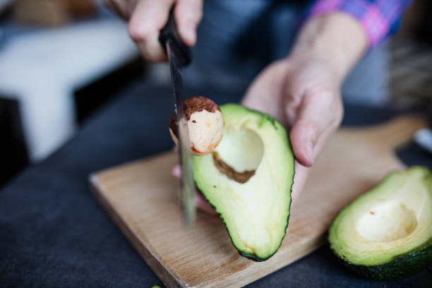 istock Close up womans hands cutting an avocado 646044478