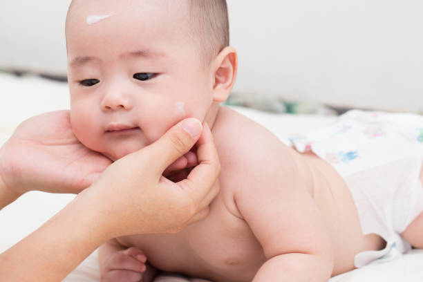 istock Mother applying baby lotion for son 646048134
