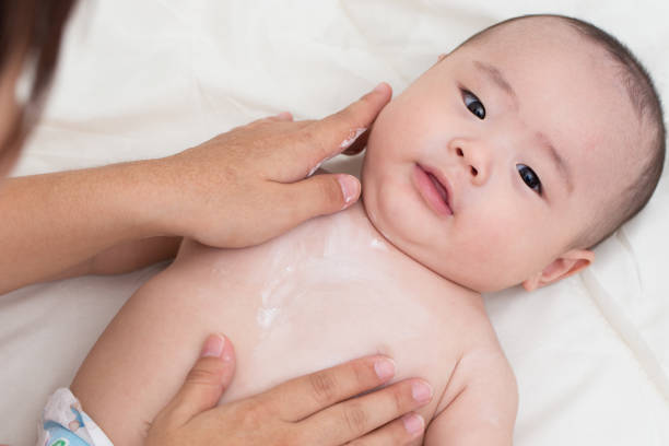 istock Mother applying baby powder for son 646048306