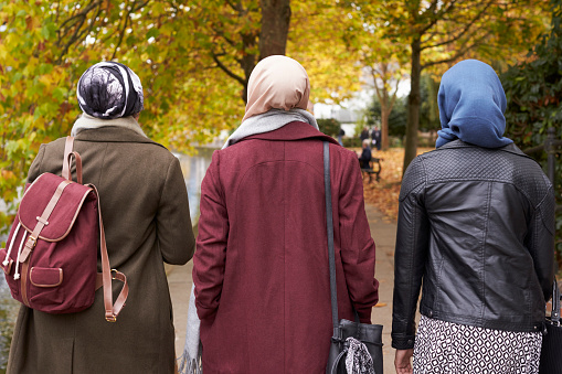 Británicos musulmán amigas caminando en entorno urbano photo