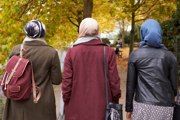 amiche musulmane britanniche che camminano nell'ambiente urbano - velo foto e immagini stock