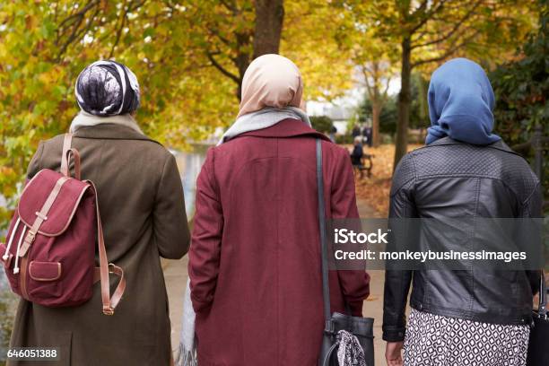 British Muslim Female Friends Walking In Urban Environment Stock Photo - Download Image Now