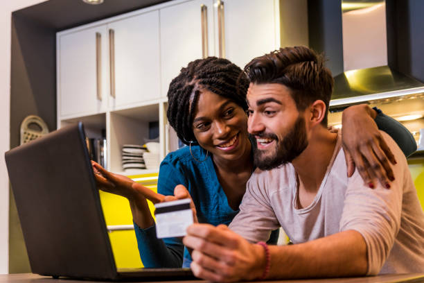 istock Young beautiful couple in kitchen ordering food online 646055364