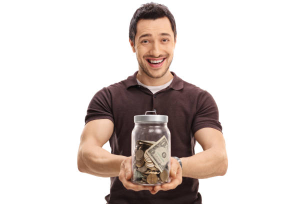 istock Joyful guy holding a jar full of money 646055558