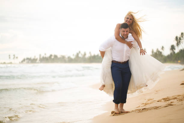 istock bride and groom having fun on the beach 646058404