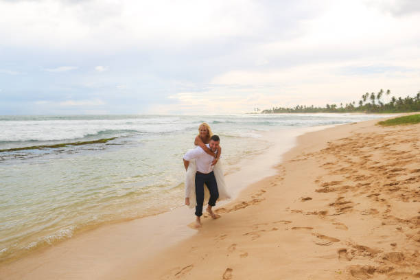 istock bride and groom having fun on the beach 646061424