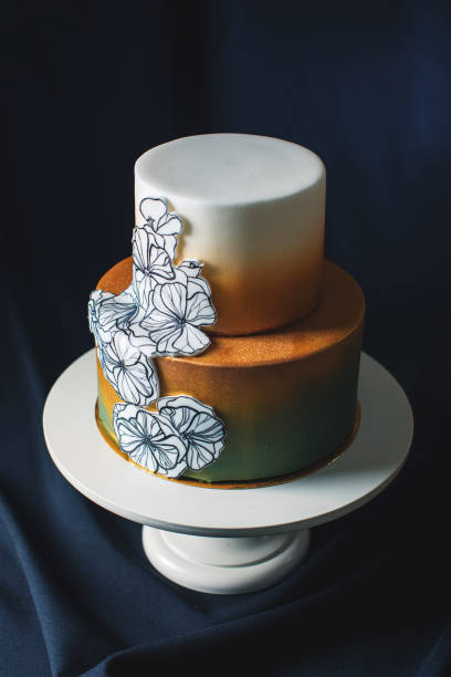 istock wedding cake decorated gold, green gradient with hand drawn flowers 646062246