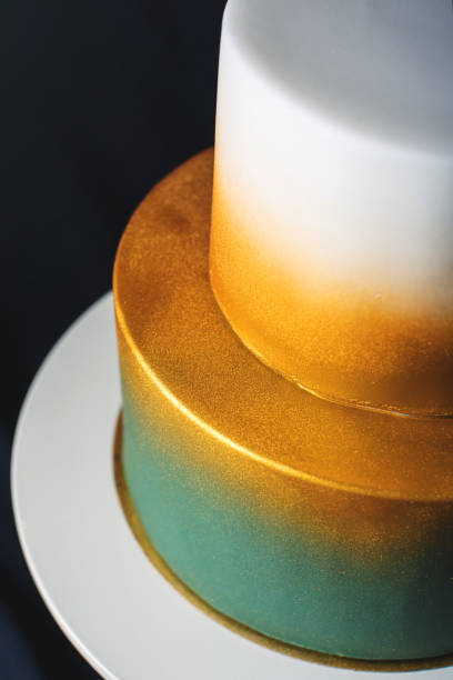 istock wedding cake decorated gold, green gradient with hand drawn flowers 646062286