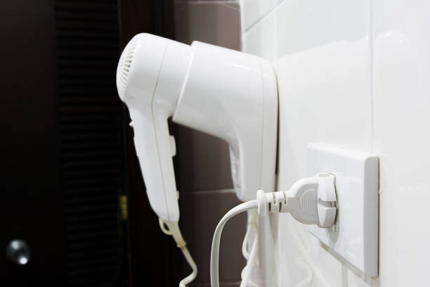 istock Hair Dryer Plug hanging on wall in bathroom 646074098