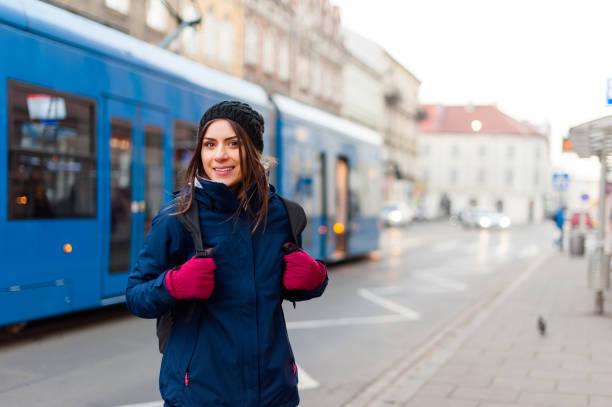 istock Girl standing in station with tram passing by 646078874