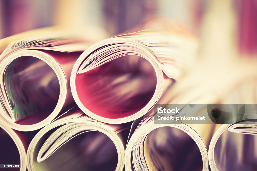 edge of colorful magazine stacking roll Close up edge of colorful magazine stacking roll with  blurry bookshelf background for publication and publishing concept , extremely DOF with vintage retro color tone Printing Press Stock Photo