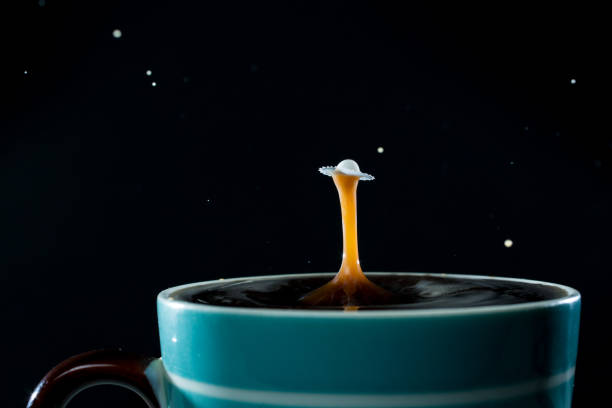 istock Milk drops splashing into a cup of coffee 646084394