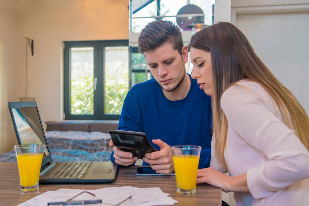 istock Positive couple with financial documents and laptop in home interior 646088186