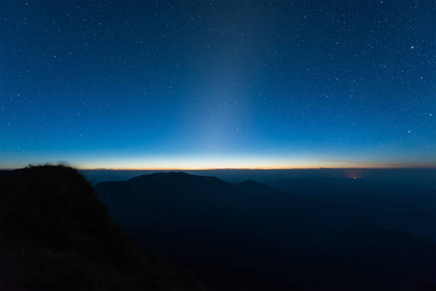 istock Stars illuminated above dark silhouette mountain before sunrise 646088798