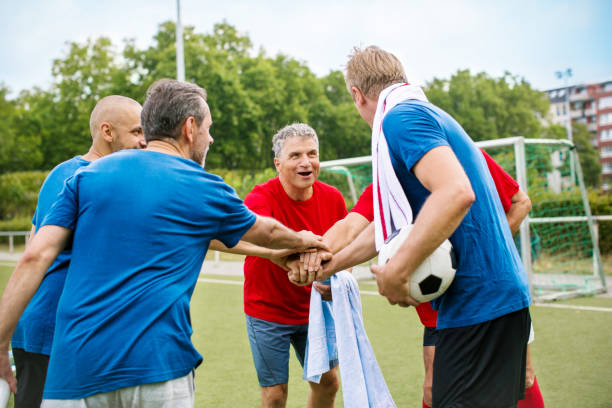 istock Senior soccer players putting their hands together 646101572