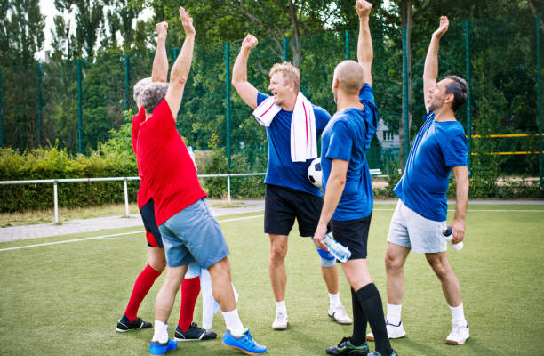 istock Senior soccer team cheering and celebrating 646101576
