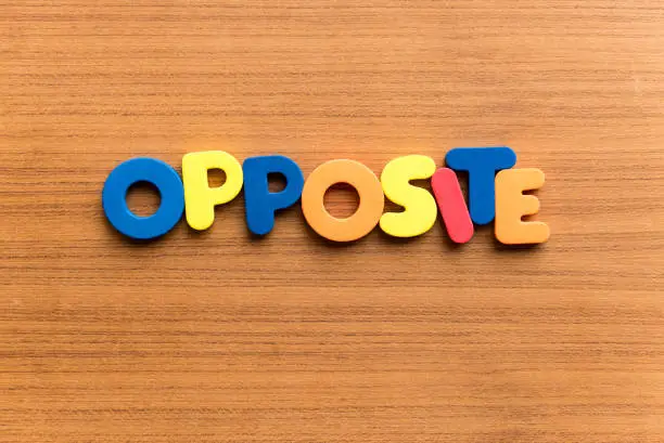 opposite colorful word on the wooden background