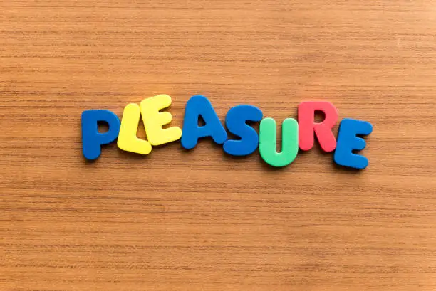 pleasure colorful word on the wooden background