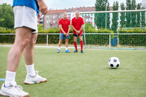 istock Senior men playing football on field 646102580