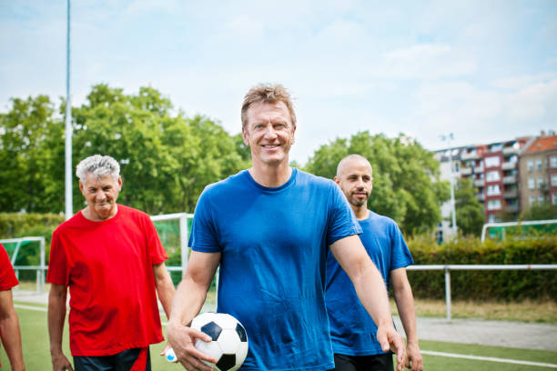 groupe des aînés du maillot de football sur le terrain de soccer - foot walk photos et images de collection