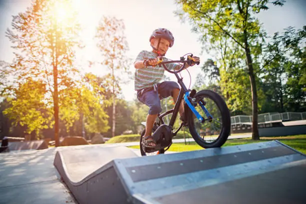 Photo of Little boy riding a bicycle on ramp