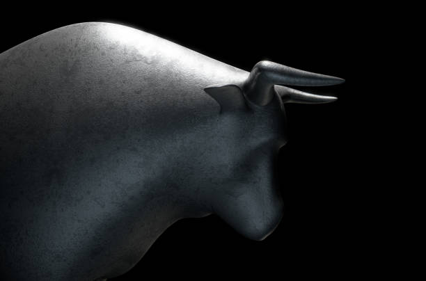 Metal casting depicting a stylized bull in dramatic light representing financial market trends
