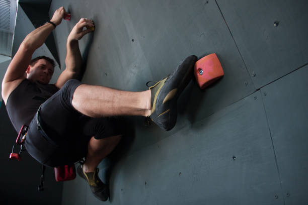 Low angle view of woman climbing on a wall.