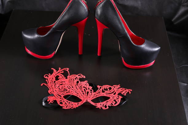 istock Black shoes on a heel and a red face pack on a black background 646124670