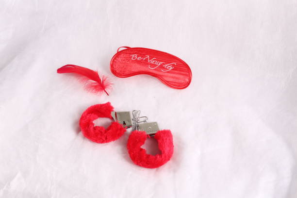 istock Erotic sexual face pack and handcuffs with fur on a white background 646125030