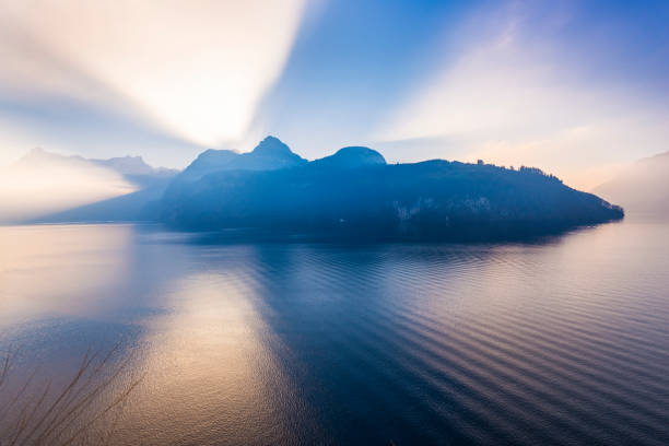 Grand game of light and shadow. Sunlight sat behind a mountain ridge. Rays of light pierce the. Extra wide lens