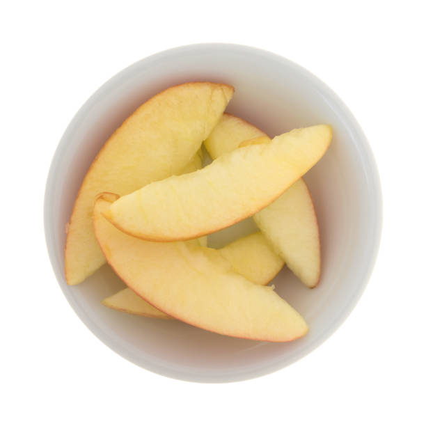 Close-up view of sliced apples in a sweet cinnamon sauce being prepared for baking into an apple pie.