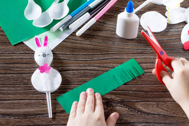 istock The child sticks gift items. Children's Easter gift toy Rooster and the Easter Bunny. Made by hand. Children's Art Project, needlework, crafts for children. 646154730