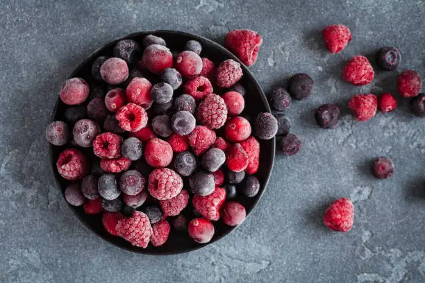 Photo of Frozen raspberry, blueberry, cranberry on grunge background