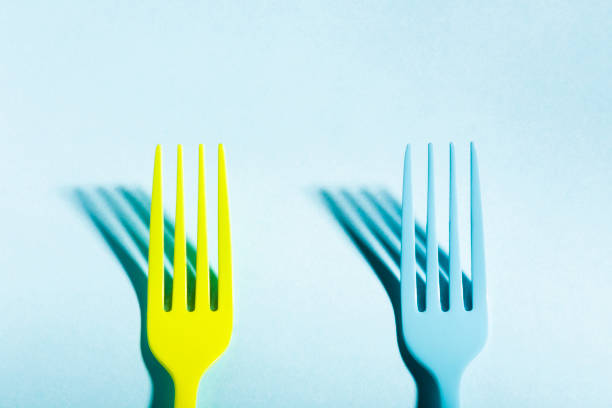 istock Yellow and blue forks on blue background 646165060
