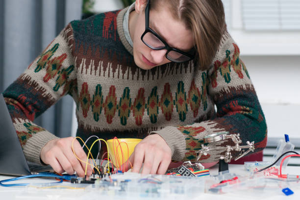 istock Young man intently working with electronic parts 646165250