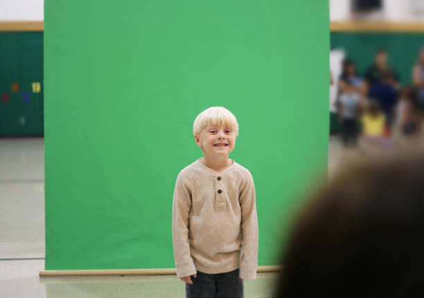 Preschool Child Getting School Picture Taken A cute 4 year old Preschool child is smiling as they get their school picture taken in front of a green screen. school picture stock pictures, royalty-free photos & images