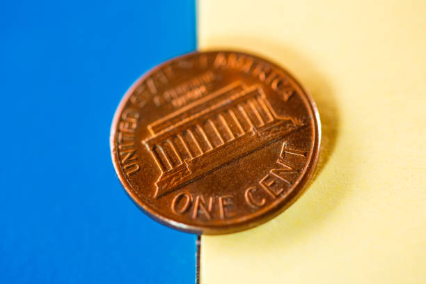 istock One cent coin in yellow blue background 646168976