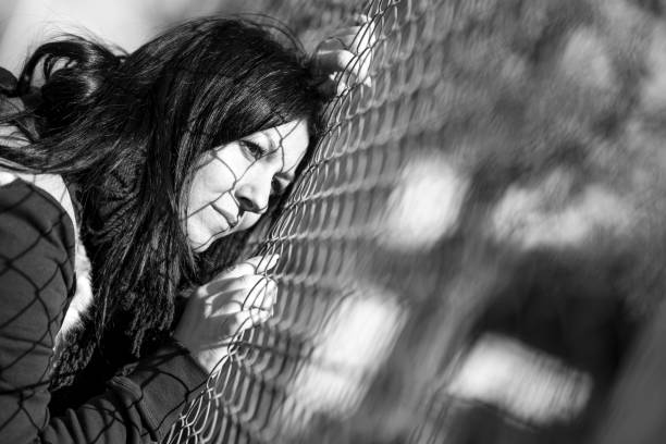 istock Young woman by the wire fence 646169272