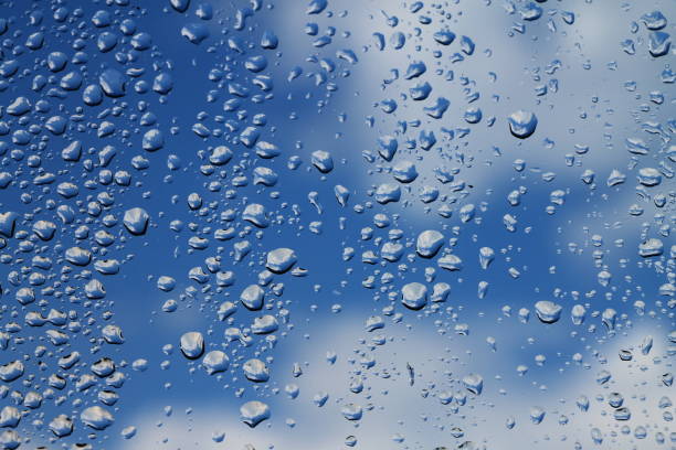 istock Rain drops on window with blue cloudy sky in background , spring rainy day 646175446